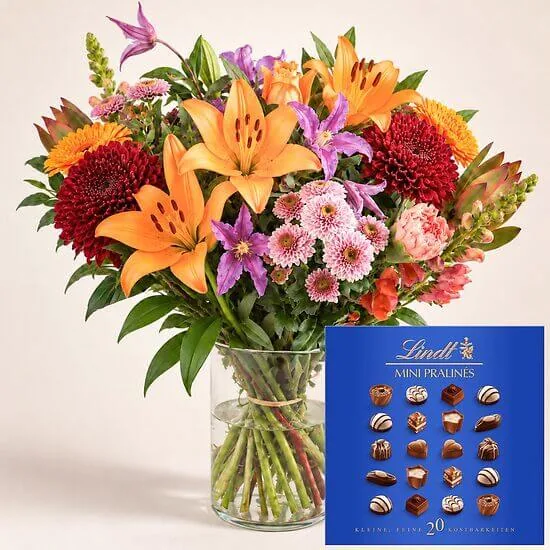 Affection: autumn bouquet of orange lilies and pink chrysanthemums in a vase with a box of mini pralines