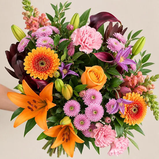 Hand holding the Affection bouquet with gerbera, lilies and carnations