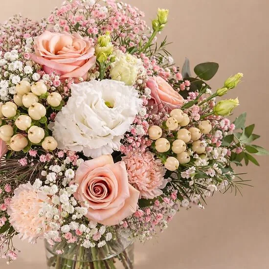 Peach roses, white lisianthus, hypericum berries and pink gypsophila in the Bienvenue au monde bouquet