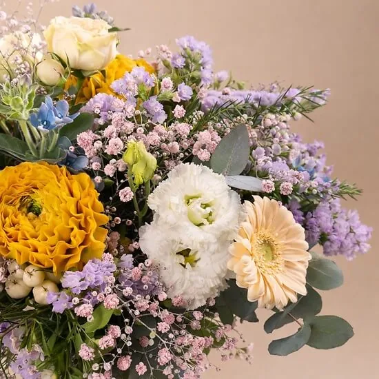 Close-up of yellow ranunculus, white lisianthus and lilac flowers